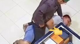 Oknum polisi terlihat berusaha mengeluarkan sesuatu diduga sabu dari saku celananya sendiri (moji tunjuk-red) saat membekuk dan menghimpit Rahmadi.(Ist)